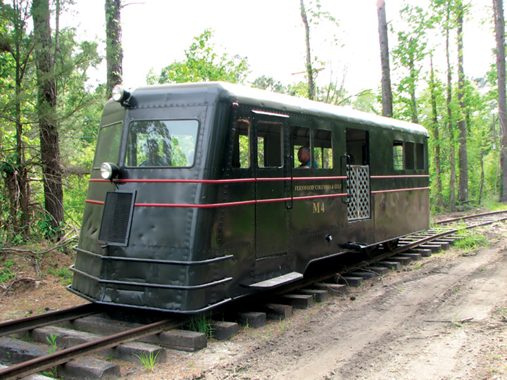 An M4 passenger railroad car carries visitors on a circle track around the Southern Forest Heritage Museum. Vehicles of this type were formerly used to transport workers from mills to logging sites. Photo by Jason Rose.