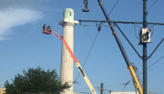 Workers use cranes to remove the statue of Confederate General Robert E. Lee from its pedestal.