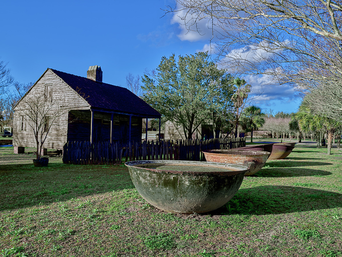 Enslaved Peoples’ Cabins and Sugarcane Boiling Kettles at Whitney Plantation, 2021